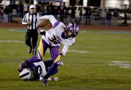 Tiger quarterback Alden McDaniel breaking a tackle, turning a loss into a big gain .